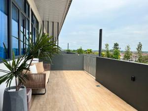 - un balcon avec des chaises et une plante dans un bâtiment dans l'établissement Hanns Spacious Balcony&SwimPool with FREE Netflix-6pax, à Sibu