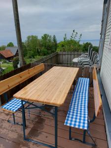 a wooden table and two chairs on a deck at Bauernhaus Hinterbühle in Wolfhalden 