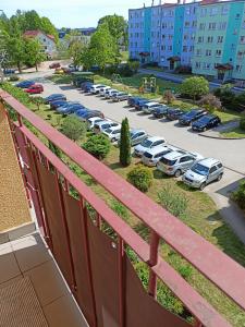 a balcony with cars parked in a parking lot at Apartament Mazury in Olecko