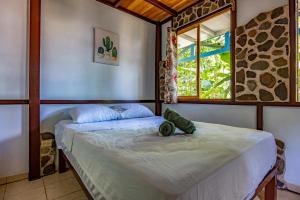 a bedroom with a large bed with a window at Uvita River Guesthouse in Uvita