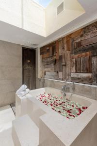 a bathroom with a bath tub filled with flowers at The Chand's Boutique Villa Batu Belig in Seminyak