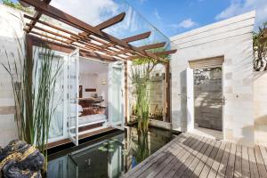 a glass house with a koi pond in the yard at The Chand's Boutique Villa Batu Belig in Seminyak