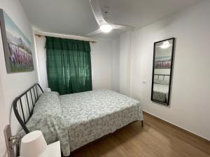 a bedroom with a bed and a green curtain at Casa Melina in Arona