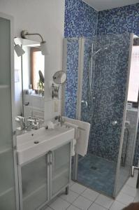uma casa de banho com um chuveiro, um lavatório e um chuveiro em Fewo Summertime em Hehlen