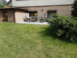 a house with two chairs and a table in the yard at Alt Sammit in Alt Samitz