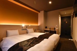 ein Hotelzimmer mit zwei großen Betten in der Unterkunft FL Hotel Dotonbori in Osaka