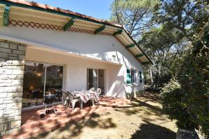 a patio with a table and chairs in front of a house at Pascalou - Hossegor situation privilégiée entre lac et océan pour cette villa in Soorts-Hossegor