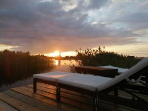 a bed on a dock with the sunset in the background at Fisherman's cottage in Björköby