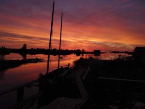 a sunset over a body of water with boats at Fisherman's cottage in Björköby +60 photos