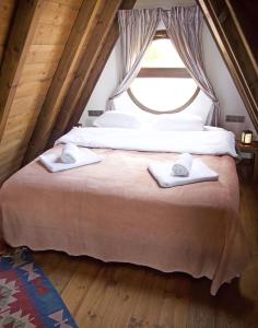 a bedroom with a bed with two towels on it at Yaban Yasam Chalets in Yolcatı