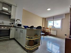 kuchnia z blatem, stołem i krzesłami w obiekcie Noly Apartamento w mieście Monforte de Lemos