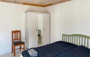 um quarto com uma cama, uma cadeira e um armário em Awesome Apartment In Huskvarna With Wifi em Huskvarna