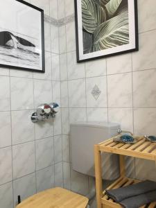uma casa de banho com WC e fotografias na parede em Gemütliches Apartment mit wundervollem Weitblick em Löffingen