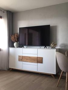 a white entertainment center with a flat screen tv on it at Gemütliches Apartment mit wundervollem Weitblick in Löffingen
