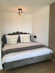 a bedroom with a large bed with white pillows at Gemütliches Apartment mit wundervollem Weitblick in Löffingen