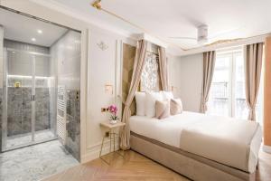 una camera bianca con un letto e una finestra di Luxury 3 Bedroom & 3 Bathroom Apartment - Louvre a Parigi