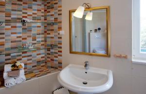 a bathroom with a sink and a mirror at Bed & Breakfast Vila Baguc in Split