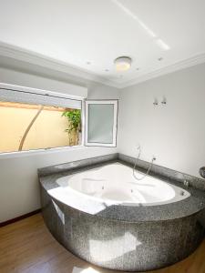 eine große Badewanne in einem Zimmer mit Fenster in der Unterkunft Hotel Raul's in Gaspar