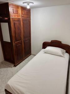 um quarto com uma cama e um armário de madeira em Acogedor apartamento cerca al centro de Medellin em Medellín