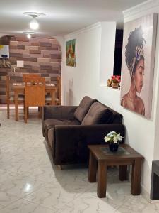 a living room with a brown couch and a table at Acogedor apartamento cerca al centro de Medellin in Medellín