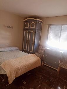 マルベーリャにあるbeach houseのベッドルーム1室(ベッド1台付)、木製キャビネットが備わります。