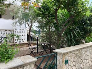 einen Garten mit einem Zaun, einem Tisch und Bäumen in der Unterkunft Villa Dune in Campomarino