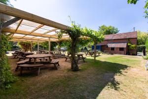 a group of picnic tables under a pavilion at The Woolpack Glamping in Maidstone