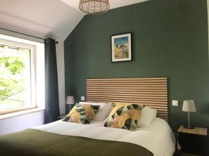 - une chambre dotée d'un lit avec un mur vert dans l'établissement Le Clos de la Morière, à Mont-Dol