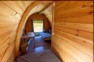 an inside view of a log cabin with a bed in a room at The Woolpack Glamping in Maidstone