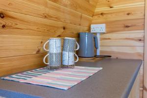 a kitchen counter with three vases on a table at The Woolpack Glamping in Maidstone