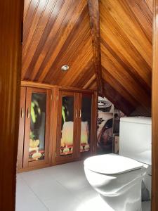 a bathroom with a toilet and a wooden ceiling at Cabo de Veiga in Trabada