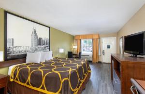 a hotel room with a bed and a flat screen tv at Super 8 by Wyndham Nashville West in Nashville