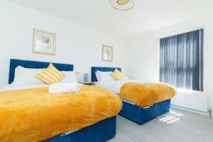 a bedroom with two beds with yellow and white pillows at Monroe House Leeds in Leeds