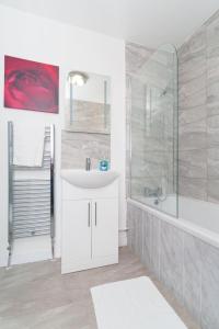 a white bathroom with a sink and a shower at Monroe House Leeds in Leeds