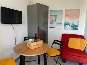 Zimmer mit einem Tisch und Stühlen sowie einem TV in der Unterkunft Villa Dune in Campomarino