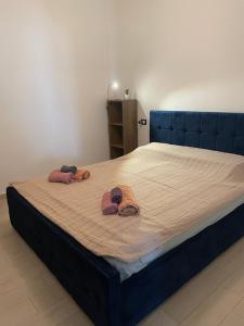 uma cama com duas toalhas e dois chinelos em Swallow Nest em Durrës