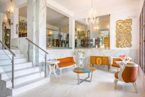 un vestíbulo con escaleras, sillas y una lámpara de araña en Leandros Hotel, en Nea Roda