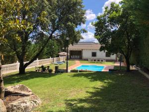 a yard with a swimming pool and a house at El Magnoliio in Santa Cruz de Pinares