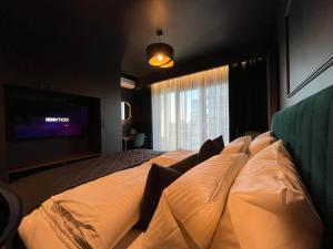 a bedroom with a large bed with a flat screen tv at Apartament Manhattan Premium - I-wsza Dzielnica - by Kairos Apartments in Katowice