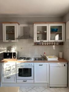 a kitchen with white cabinets and a sink at Apartment s Jukica in Vis