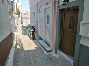 una motocicleta estacionada en un callejón al lado de un edificio en Samos House, en Samos