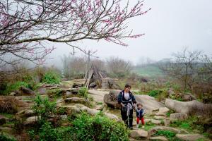 a woman and a child standing on rocks at Legend Home Sapa in Sa Pa