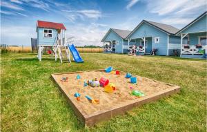 a sandbox in the middle of a yard with a house at Gorgeous Home In Jaroslawiec With Kitchen in Jarosławiec