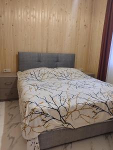 a bedroom with a bed with a tree printed on it at Коттедж у моря in Batumi