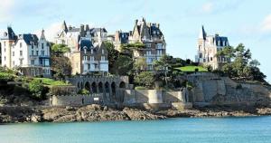 un grand château au sommet d'une colline à côté de l'eau dans l'établissement La Goélette Beau duplex A 150 m du centre ville et 400m de la plage de l'écluse, à Dinard