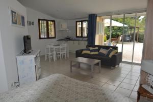 a living room with a couch and a table at Studio au coeur d'un jardin reposant in Saint-Thibéry