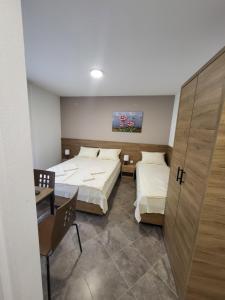 1 Schlafzimmer mit 2 Betten, einem Tisch und einem Stuhl in der Unterkunft Vila Pčelica Petra in Sokobanja