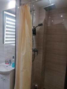 La salle de bains est pourvue d'une douche avec rideau de douche. dans l'établissement Apartament przy puszczy, à Hajnówka
