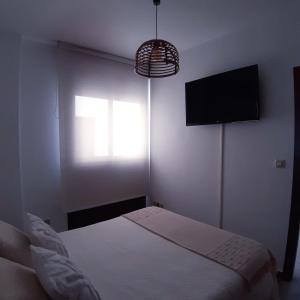 a bedroom with a bed and a flat screen tv at La Casita del Arroyo in Arroyo Frio +13 photos