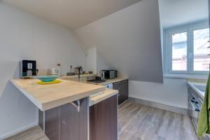 a large kitchen with a counter top and a window at Le Sunset Beach (les pieds dans l'eau) vue mer exceptionnelle in Fécamp